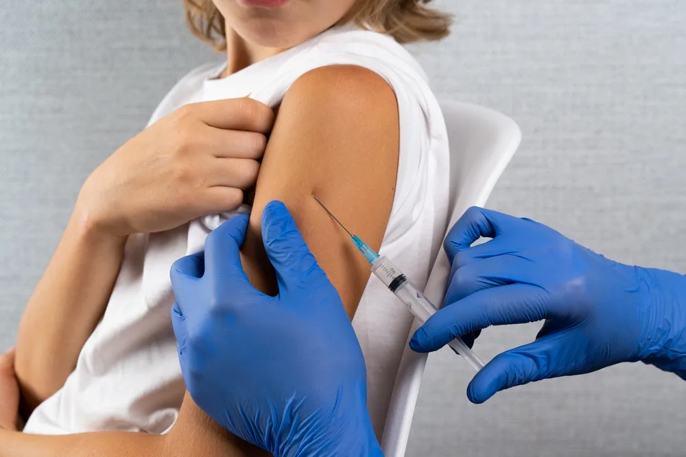 Asistenta medicala care face o injectie