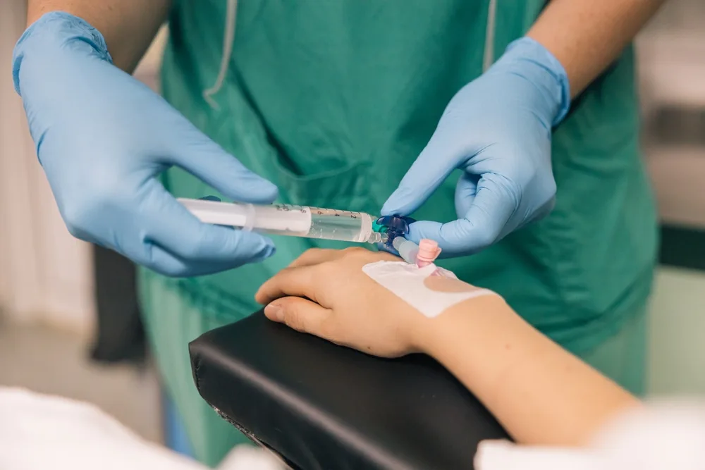 asistenta medicala monteaza o branula unui pacient